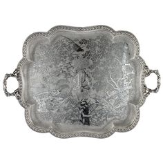 an ornate silver tray with birds and flowers on it