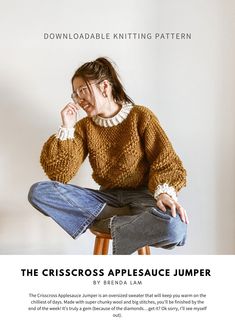 a woman sitting on top of a stool wearing a sweater