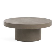 a round concrete table sitting on top of a white floor