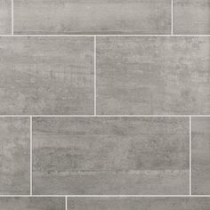 a gray tile wall with white grouting in the center and grey tiles on the bottom