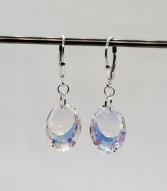 These beautiful sterling silver earrings have sparkling Swarovski Crystal Clear AB Oval pendants hung on a closure of your choice. Shape: Oval 6120 Color: Clear AB Pendant Size: 18x12mm The Aurora Borealis (AB) coating creates an iridescent rainbow effect which adds sparkling flashes of yellow, blue, and pink tones depending on the angle of light.  If a pendant appears "blue" in the photo, it is because my camera seems to pick up on the flashes of blue hues more so than the other colors.  Choose Silver Jewelry Fashion, Pink Tone, Oval Pendant, Aurora Borealis, Pendant Earrings, Aurora, Sterling Silver Earrings, Swarovski Crystals, My Jewellery