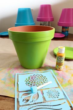 there are some crafting supplies sitting on the table next to it's flower pot