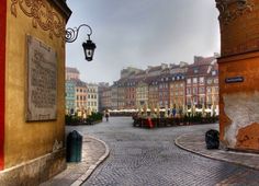 an empty cobblestone street with buildings in the background and a lamp post on one side