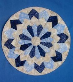 a blue and white circular quilt on a blue background