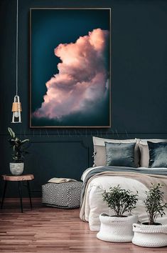 a bedroom with dark walls and wooden flooring has a large painting hanging above the bed