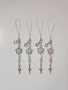 four different colored charms hanging from hooks