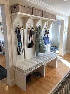 an entryway with several coats and purses hanging on the coat rack above it