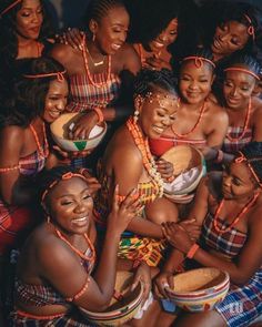 a group of women dressed in colorful clothing and headdress are posing for the camera