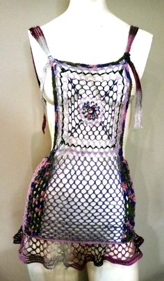 a white mannequin wearing a purple and black netted top with pink trim