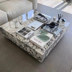 a marble coffee table with books and magazines on it