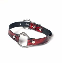 a red and black leather collar with metal clasps