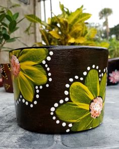 painted flower pot sitting on top of a table