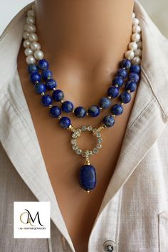 This exquisite piece pairs lustrous freshwater pearls, known for their lustrous and iridescent appeal, with the deep blue charm of genuine Lapis Lazuli gemstones. Elegant Royal Blue Beaded Jewelry, Elegant Round Lapis Lazuli Beaded Necklaces, Elegant Round Beaded Lapis Lazuli Necklace, Elegant Round Lapis Lazuli Beaded Necklace, Handmade Elegant Lapis Lazuli Beaded Necklaces, Elegant Lapis Lazuli Gemstone Beaded Necklaces, Elegant Lapis Lazuli Gemstone Beaded Necklace, Elegant Beaded Lapis Lazuli Necklace, Blue Gemstone Wedding Necklace