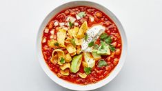 a white bowl filled with beans, avocado and sour cream