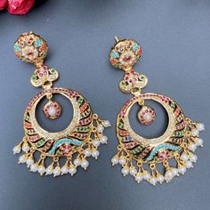 Featured are a pair of light and intricately crafted chandbalis in gold plated silver, studded with freshwater pearls and synthetic navratan lookalike stones. The earrings weigh 20gms Wath Video Here Luxury White Meenakari Chandbalis, Chandbali Jhumkas For Designer Wear, Chandbali Jhumkas With Cutdana For Designer Wear, Chandbali Cutdana Jhumkas For Designer Wear, Traditional Chandbali Jhumkas For Designer Wear, Elegant Chandbalis With Cutdana For Designer Wear, Bollywood Style Designer Earrings With Cutdana, Designer Chandbalis With Tilla For Diwali, Bollywood Style Chandbali Earrings For Designer Wear