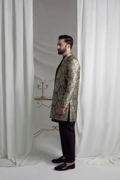 Upgrade your style with our Black and Gold Prince Coat. Made from luxurious brocade material, this front open coat exudes royalty. Paired with an Indian raw silk kurta pajama, it's the perfect ensemble for any formal event. Elevate your look and make a statement with this unique and elegant piece. 3-Piece Suit Designer Silk Fitted Outerwear, Fitted Silk Outerwear, Elegant Semi-formal Sets For Eid, Designer Straight Kurta Bandhgala For Ceremonial Occasions, Designer Ceremonial Bandhgala With Straight Kurta, Designer Nehru Jacket With Zari Work For Festive, Designer Festive Nehru Jacket With Zari Work, Elegant Traditional Drape Outerwear For Party, Elegant Party Outerwear With Traditional Drape