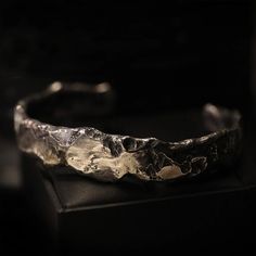 If you're the type of person to wear chunky jewelry, you came to the right place. This heavy piece of sterling silver weighs 63 grams and works well as a set with the Ring of the Elders. The Cuff of the Elders combines rough surfaces with polished areas. The inside of the band has 'Book of Alchemy' engraved in it. The width of the band is 1.5cm, the inside diameter of the piece is 6.9cm. Shipping&Processing Since all our items are individually handmade, we need about 4 weeks (at most) to make yo Brutalist Oxidized Metal Jewelry, Silver Hand Cast Metal Cuff Bracelet, Silver Metal Cuff Bracelet Hand Cast, Hand Forged Silver Brutalist Jewelry, Hand Cast Brutalist Metal Jewelry, Hand Cast Metal Brutalist Jewelry, Brutalist Hand Cast Metal Jewelry, Unique Silver Hammered Jewelry, Unique Hammered Silver Jewelry