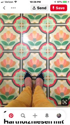 a person standing in front of a tiled floor with colorful flower designs on it's sides