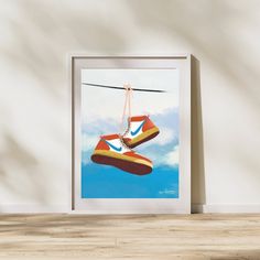 a painting of two shoes hanging from a line in the air with clouds behind them