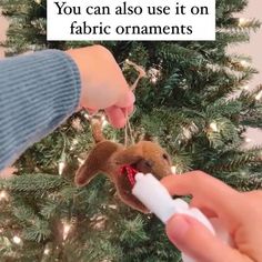 someone is decorating a christmas tree with an ornament that looks like a deer