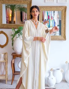 Elevate your wardrobe with our " Embellished Crepe Kaftan ," a stunning crepe kaftan that embodies the essence of Moroccan elegance and craftsmanship.   Product Details:     Crafted from Premium Crepe: This kaftan is made from 100% crepe, ensuring a lightweight and comfortable feel against your skin.    Signature Moroccan Embellishments: Adorned with intricate golden "sfifa" and delicate pearls, this kaftan is a masterpiece of Moroccan design. The embellishments add a touch of opulence and tradi Moroccan Outfit, Silk Abaya, Morrocan Fashion, Sangeet Ceremony, White Kaftan, Moroccan Clothing, Kaftan Designs, Moroccan Kaftan, Moroccan Fashion