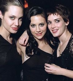 three beautiful women standing next to each other