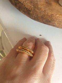 This is a very elegant ring set with 9-11 black saphire. It is a wavy asymmetrical ring. Its made of goldFilled that will not tarnish. - Goldfilled - Set with 9-11 blue sapphire -Free shipping -Comes in a gift box If you would like to see other rings I have made, please follow this link: https://www.etsy.com/il-en/shop/TamyZurTachshit?ref=seller-platform-mcnav&section_id=17271018 If you would like to go back to my store follow this link: https://www.etsy.com/il-en/shop/TamyZurTachshit?ref=se Elegant Gold Stackable Sapphire Rings, Modern Black Spinel Rings As Gift, Black Spinel Sapphire Ring For Anniversary, Elegant Gemstone Snake Ring For Anniversary, Elegant Black Spinel Sapphire Ring For Anniversary, Anniversary Rings With Black Diamonds And Spinel, Fine Jewelry Sapphire Ring With Black Spinel For Anniversary, Black Diamond Ring Jewelry, Elegant Sapphire Ring With Black Spinel For Wedding