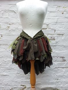 a white mannequin wearing a green and brown skirt with ruffles on it