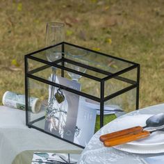 a table set with plates and silverware for an outdoor dinner party in the grass