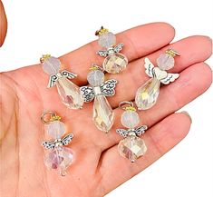 a person is holding several small charms in their hand, including one with a butterfly on it