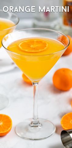 two martini glasses filled with orange juice and garnished with an orange slice on the rim