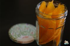 a jar filled with orange peels next to a plate