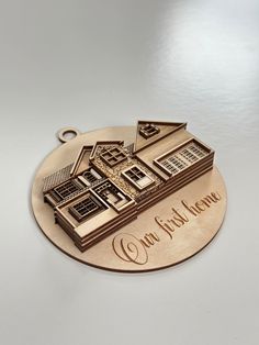 a metal ornament that says our first home with a house in the middle