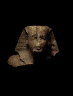 an ancient statue is shown against a black background