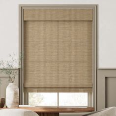 a living room with a couch, table and window blinds in shades of natural bamboo