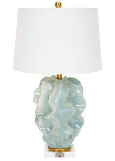 a table lamp with a white shade on it and a gold trim around the base