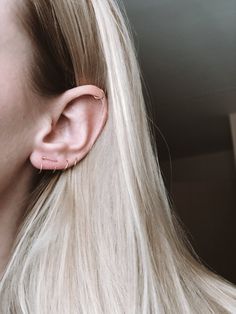 a woman with blonde hair wearing a pair of ear piercings