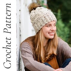 a young woman wearing a knitted hat with pompom in front of a white wall