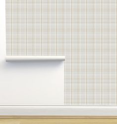 an empty room with a white wall and beige plaid pattern on the wall behind it