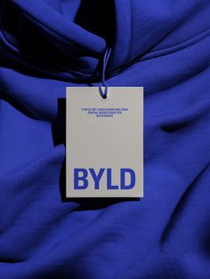 a tag that says byld hanging on a blue fabric with the word blyd printed on it