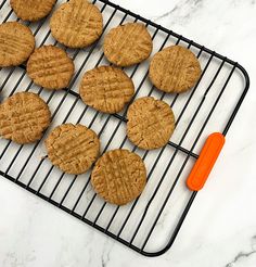 cookies cooling on a wire rack with an orange spatula