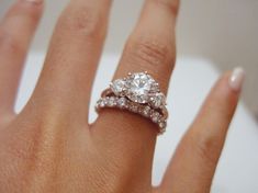 a woman's hand with two diamond rings on it