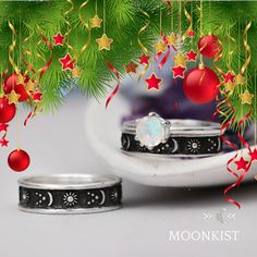 two wedding rings sitting next to each other under a christmas tree with ornaments hanging from it