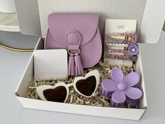 an open box containing sunglasses, purse and other items for a women's day