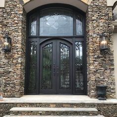 the front entrance to a home with stone steps and glass doors