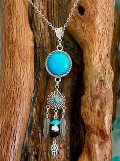 This is unique and one of a kind.Turquoise colored stone wrapped in rope like edging below sits a smaller turquoise colored stone with filigree. 2 tibetan silver feathers dangling on either side of middle dangle With small stones and tiny silver dreamcatcher The bail for holding the chain is antique Tibetan silver and generous in size if larger chain should be desired. Bohemian Turquoise Dangle Jewelry, Bohemian Turquoise Necklace With Natural Stones, Bohemian Round Turquoise Necklace With Natural Stones, Handmade Silver Turquoise Necklace In Bohemian Style, Handmade Bohemian Round Turquoise Necklace, Turquoise Feather Jewelry As A Gift, Turquoise Feather Jewelry As Gift, Bohemian Wire-wrapped Round Pendant Necklace, Bohemian Dangle Necklaces Nickel Free