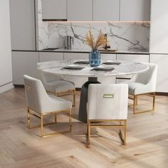 a marble dining table surrounded by white chairs and gold trimmings in a modern kitchen