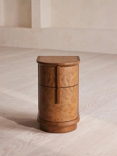 a wooden box sitting on top of a hard wood floor next to a white wall