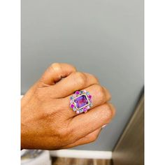 This ring has a bright and vivid purple Emerald Cut Amethyst that weighs 2.61 Carats and is embellished with 16 Multicolor Sapphires that weigh 1.13 Carats as well as 34 Round Cut Diamonds that weigh 0.17 Carats (clarity: SI1-F). The total carat weight of the ring is 3.91 Carats. The ring is crafted in 14 Karat Yellow Gold and weighs approximately 6.6 Grams.  The ring is a size 7  Exact dimensions for this item are unknown. Please reach out in the seller Q&A for any questions on measurements. Luxury Multicolor Amethyst Ring With Gemstone Accents, Luxury Purple Gemstones With Halo Setting, Fine Jewelry Purple Sapphire Ring With Accent Stones, Purple Ruby Ring With Diamond For Anniversary, Fine Jewelry Purple Amethyst Ring With Gemstone Accents, Purple Birthstone Ring With Gemstone Accents, Multicolor Luxury Amethyst Ring, Luxury Purple Sapphire Ring With Diamond, Luxury Purple Amethyst Ring With Halo Setting