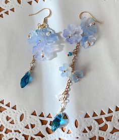 blue Sakura Flower Earrings The blue sakura flower earrings feature three glazed sakura and one crystal drop. They are really comfortable for everyday wear.  Available in GOLD and Silver finish! M A T E R I A L S * A N D * S I Z E  The hook is 14K gold filled - Length: 80mm(without the hook) - Width: 23mm Blue Whimsical Dangle Flower Earrings, Whimsical Blue Drop Earrings, Whimsical Blue Dangle Flower Earrings, Blue Flower Charm Earrings For Spring, Blue Dangle Earrings For Spring, Blue Earrings With Flower Charm For Spring, Blue Dangle Flower Earrings For Spring, Whimsical Blue Jewelry With Flower Charm, Delicate Blue Flower Earrings With Ear Wire